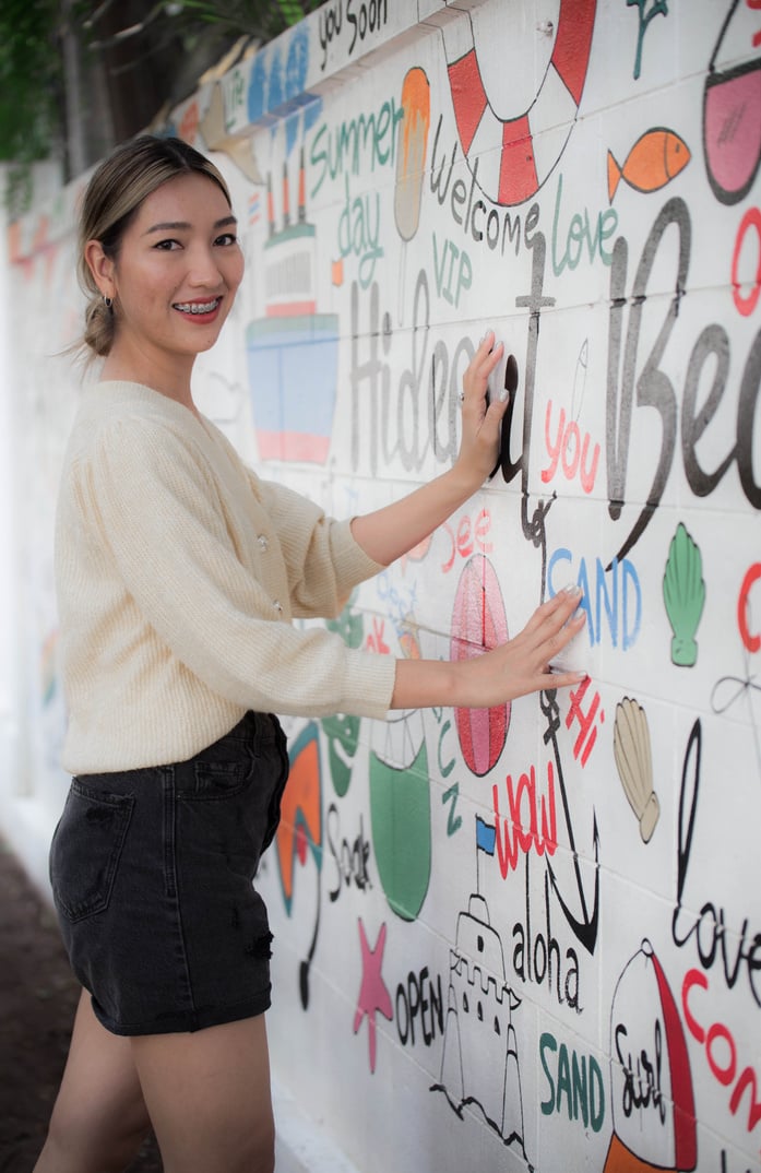 Smiling Woman Standing Near a Wall with Painting